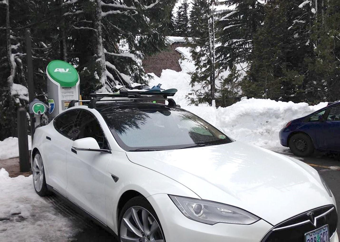 Tesla blanco cargando la batería en la nieve