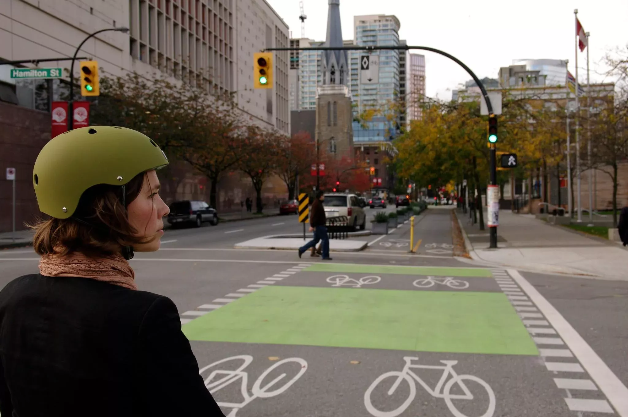 Mujer con casco en bicicleta mirando hacia carril de bicis